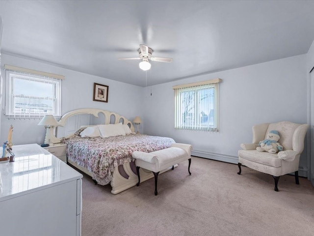 bedroom with baseboard heating, multiple windows, ceiling fan, and light colored carpet