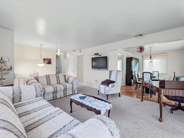 carpeted living room with a chandelier