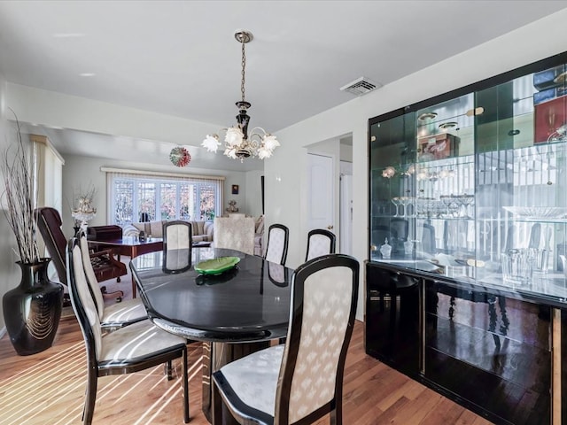 dining room featuring hardwood / wood-style flooring and an inviting chandelier