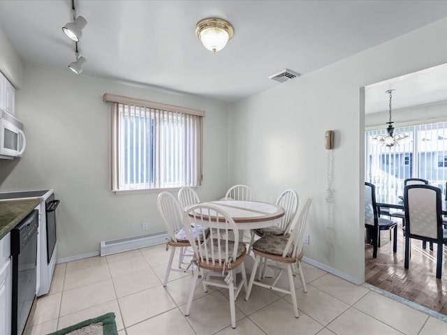 dining space featuring plenty of natural light, light wood-type flooring, track lighting, and a baseboard heating unit