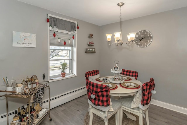 dining room featuring a notable chandelier, wood-type flooring, and baseboard heating