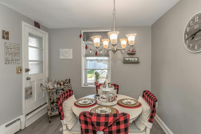 dining area with a chandelier, hardwood / wood-style floors, and baseboard heating