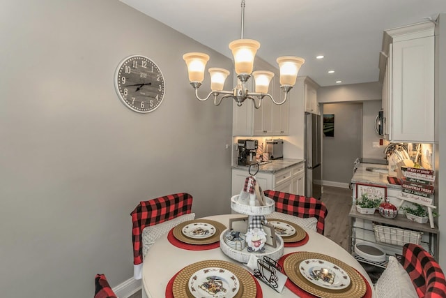 dining room featuring dark hardwood / wood-style flooring, an inviting chandelier, and sink