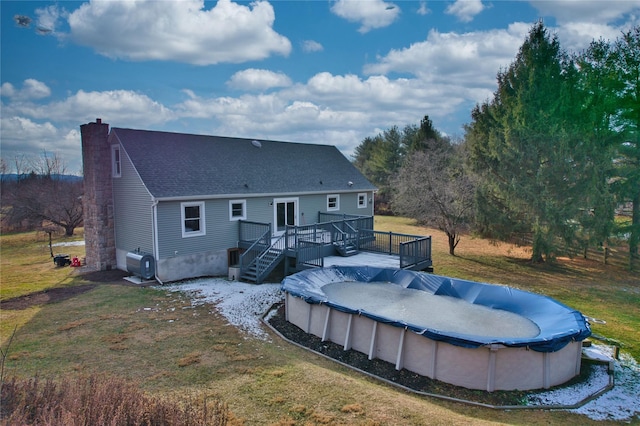 back of property featuring a lawn and a swimming pool side deck