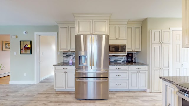 kitchen featuring stone counters, decorative backsplash, light wood-type flooring, and stainless steel appliances