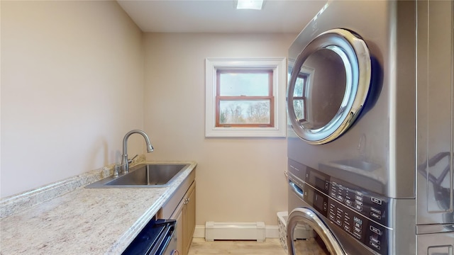 laundry room with sink, stacked washer / drying machine, and a baseboard heating unit