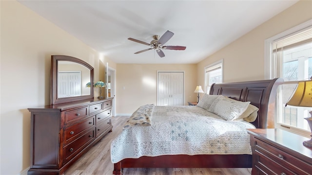 bedroom featuring ceiling fan, a closet, and light wood-type flooring