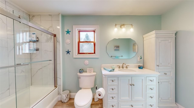 full bathroom featuring combined bath / shower with glass door, vanity, toilet, and tile patterned flooring