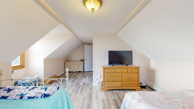 bedroom featuring a baseboard radiator, light hardwood / wood-style floors, and lofted ceiling