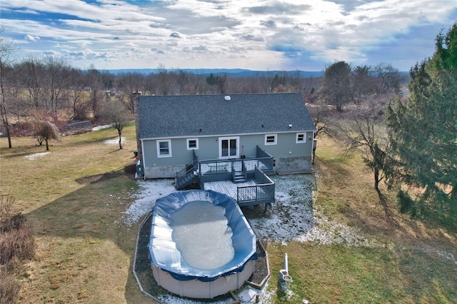 rear view of house featuring a lawn and a wooden deck