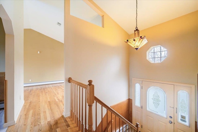 entryway featuring light hardwood / wood-style floors, high vaulted ceiling, and baseboard heating