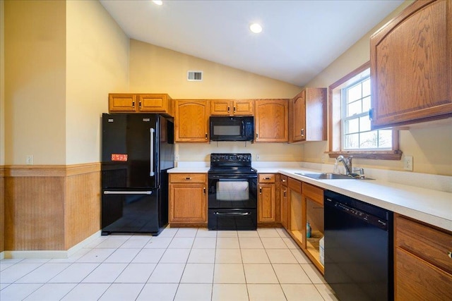 kitchen with sink, light tile patterned floors, black appliances, and lofted ceiling