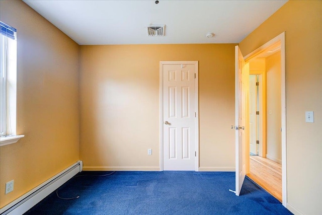 carpeted spare room featuring baseboard heating