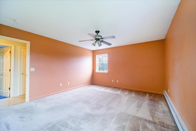 spare room with baseboard heating, light carpet, and ceiling fan