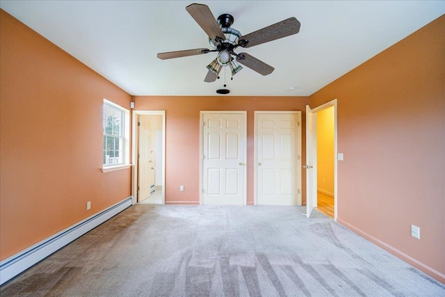 unfurnished bedroom featuring light carpet, connected bathroom, a baseboard radiator, and ceiling fan