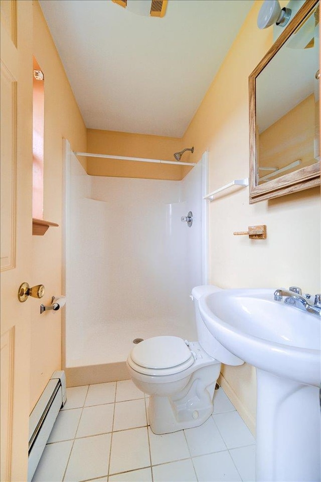 bathroom featuring tile patterned flooring, toilet, a shower, and a baseboard radiator