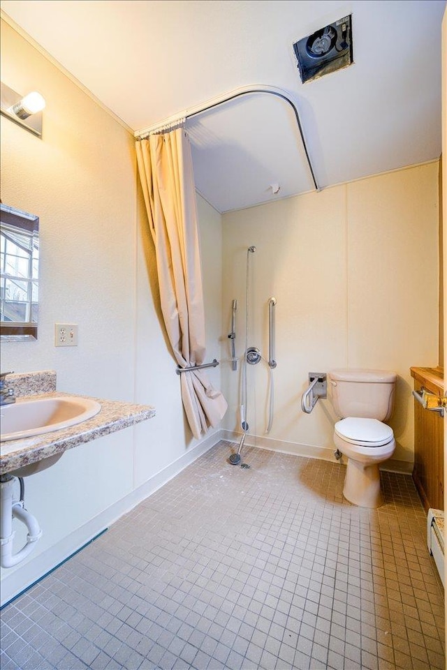 bathroom with toilet, sink, and tile patterned flooring