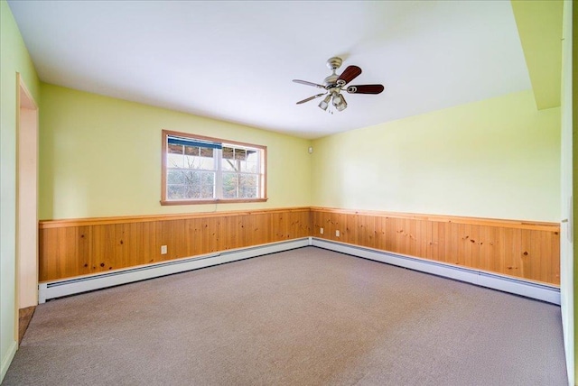 unfurnished room with carpet floors, ceiling fan, and wooden walls