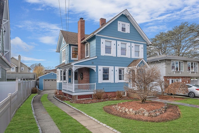 view of front of house with a front lawn, covered porch, and an outdoor structure