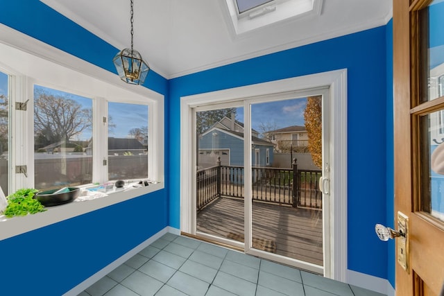 doorway with light tile patterned floors, ornamental molding, a wealth of natural light, and a skylight