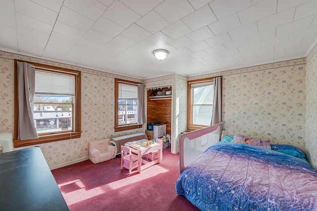 bedroom featuring carpet flooring, a closet, and multiple windows