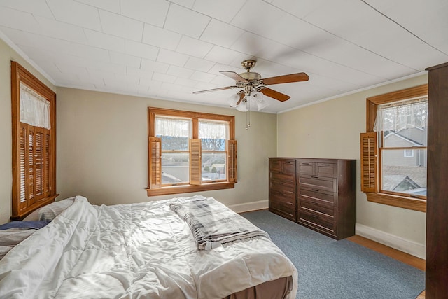 carpeted bedroom featuring ceiling fan and ornamental molding