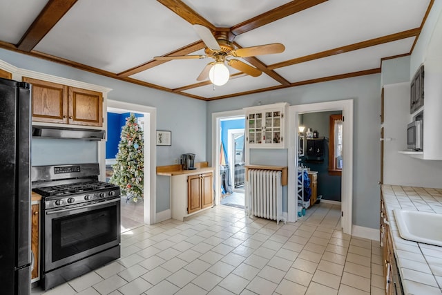 kitchen with ceiling fan, radiator heating unit, stainless steel appliances, tile countertops, and light tile patterned floors