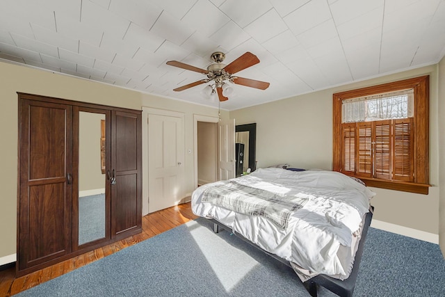 bedroom with light wood-type flooring, ceiling fan, and crown molding