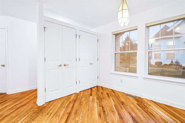 interior space with multiple closets and light hardwood / wood-style floors