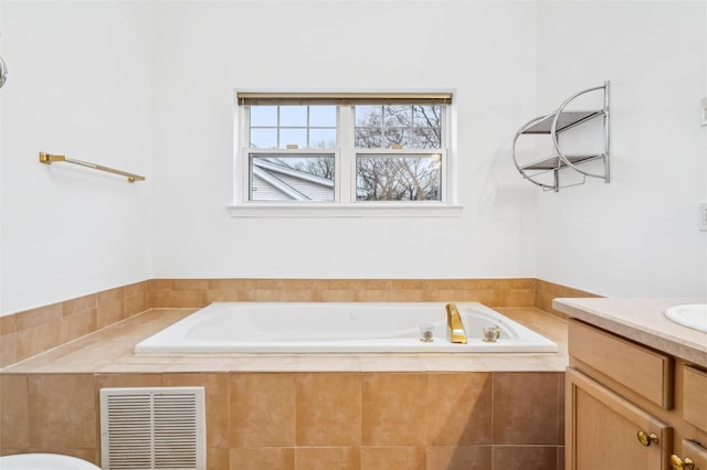 bathroom with vanity and a relaxing tiled tub