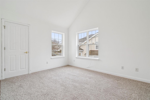 carpeted spare room featuring high vaulted ceiling