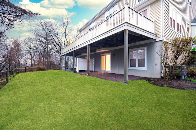 back of property with a lawn, central AC unit, and a deck