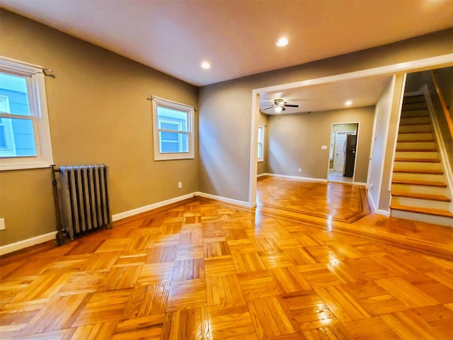 spare room with ceiling fan, radiator heating unit, and light parquet flooring