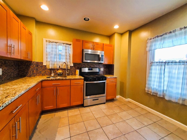 kitchen featuring decorative backsplash, stainless steel appliances, a healthy amount of sunlight, and sink