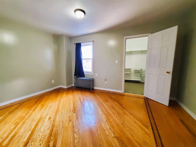 interior space featuring radiator heating unit and hardwood / wood-style flooring