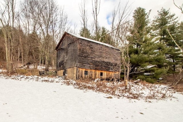 snow covered property featuring an outbuilding