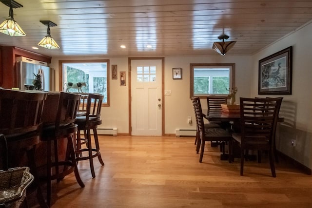 dining area with wood ceiling, a baseboard radiator, and light hardwood / wood-style floors