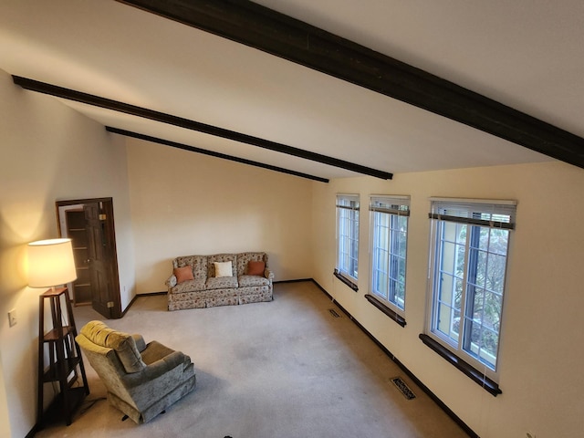 carpeted living room with beamed ceiling