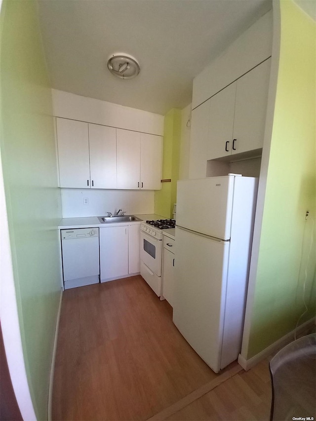 kitchen featuring white appliances, light hardwood / wood-style floors, white cabinetry, and sink