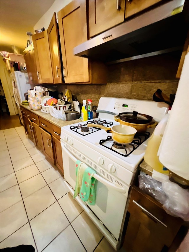 kitchen with light tile patterned flooring and white stove