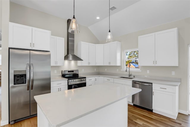 kitchen featuring sink, white cabinetry, hanging light fixtures, appliances with stainless steel finishes, and a kitchen island