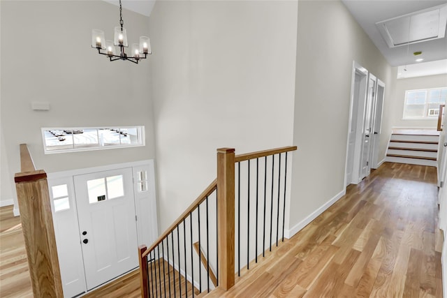 foyer entrance featuring a towering ceiling and light wood-type flooring