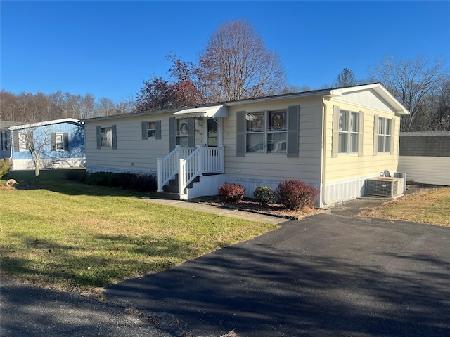 view of front of home featuring cooling unit and a front lawn