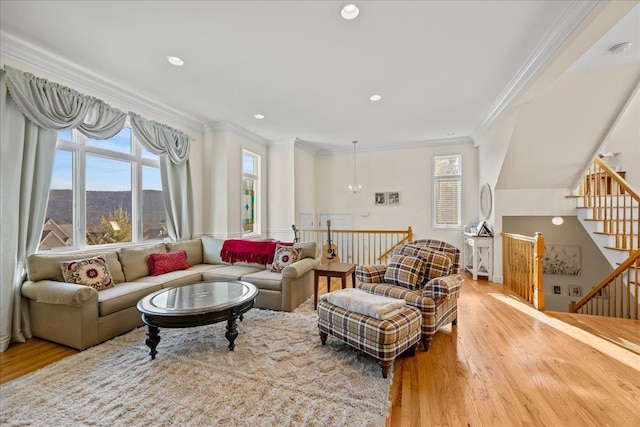 living room featuring light wood-type flooring, crown molding, and an inviting chandelier