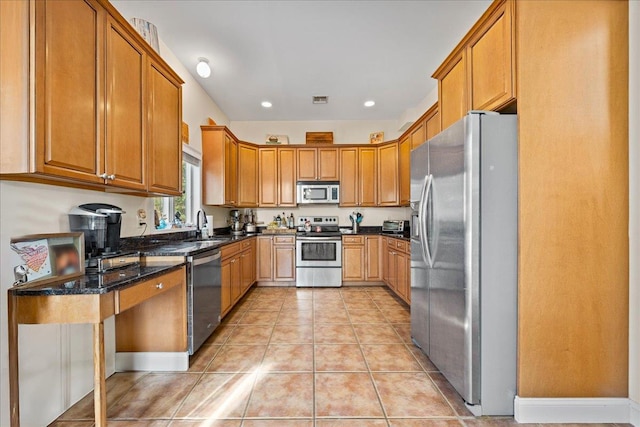 kitchen featuring light tile patterned flooring, dark stone countertops, sink, and appliances with stainless steel finishes