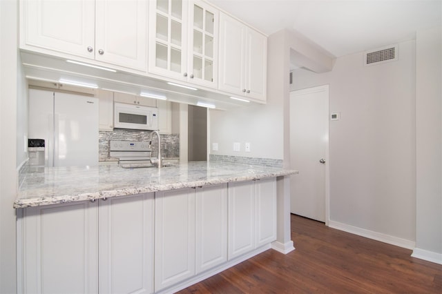 kitchen with white cabinetry, light stone countertops, white appliances, and sink