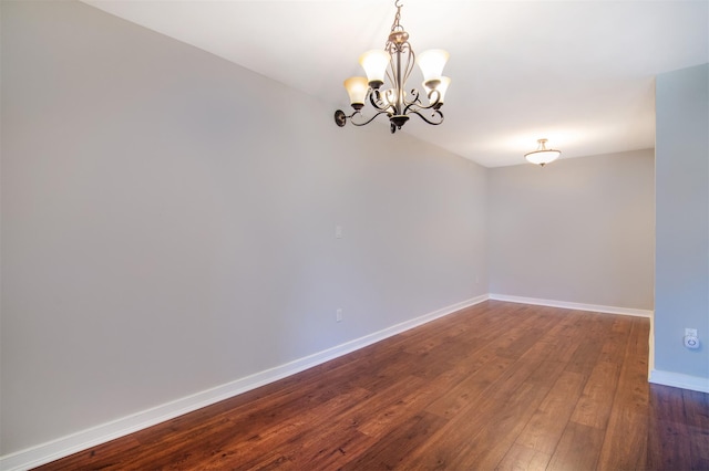 unfurnished room with dark hardwood / wood-style floors and a notable chandelier