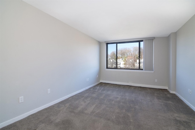 unfurnished room with dark colored carpet