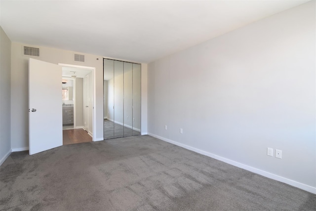 unfurnished bedroom with a closet and carpet floors