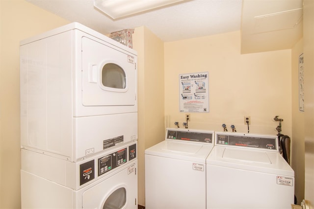 washroom with washer and dryer, a textured ceiling, and stacked washer and dryer